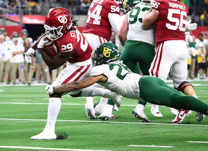 Dec 7, 2019; Arlington, TX, USA; Oklahoma Sooner running back Rhamondre Stevenson (29) runs with the ball for an overtime touchdown against Baylor Bears linebacker Terrel Bernard (26) in the 2019 Big 12 Championship Game at AT&T Stadium.
